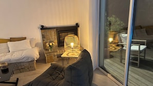 A cozy living room with a fireplace, comfortable seating, and a view through a glass door. - 1st level villa overlooking the sea and the village - 300m from shops and restaurants (La Croix-Valmer)