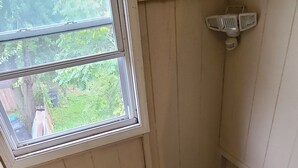 A narrow wooden staircase with a window at the top, leading to a lower level.