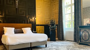 Habitación de hotel con una cama grande, chimenea y vistas al exterior.
