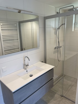 Een douche, een haardroger, handdoeken, toiletpapier