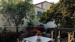 A patio with a checkered floor, a table, and four chairs. - Nava Suites (San Cristóbal de La Laguna)