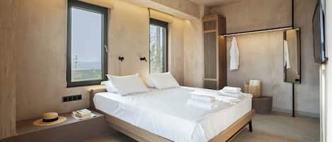 Une chambre moderne avec un grand lit, un ventilateur de plafond, une fenêtre et un miroir.