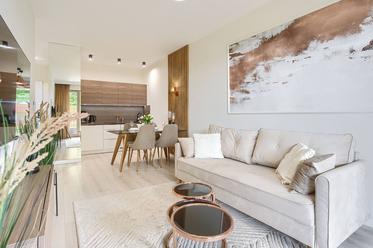 A modern living room with a sofa, coffee table, and dining area.