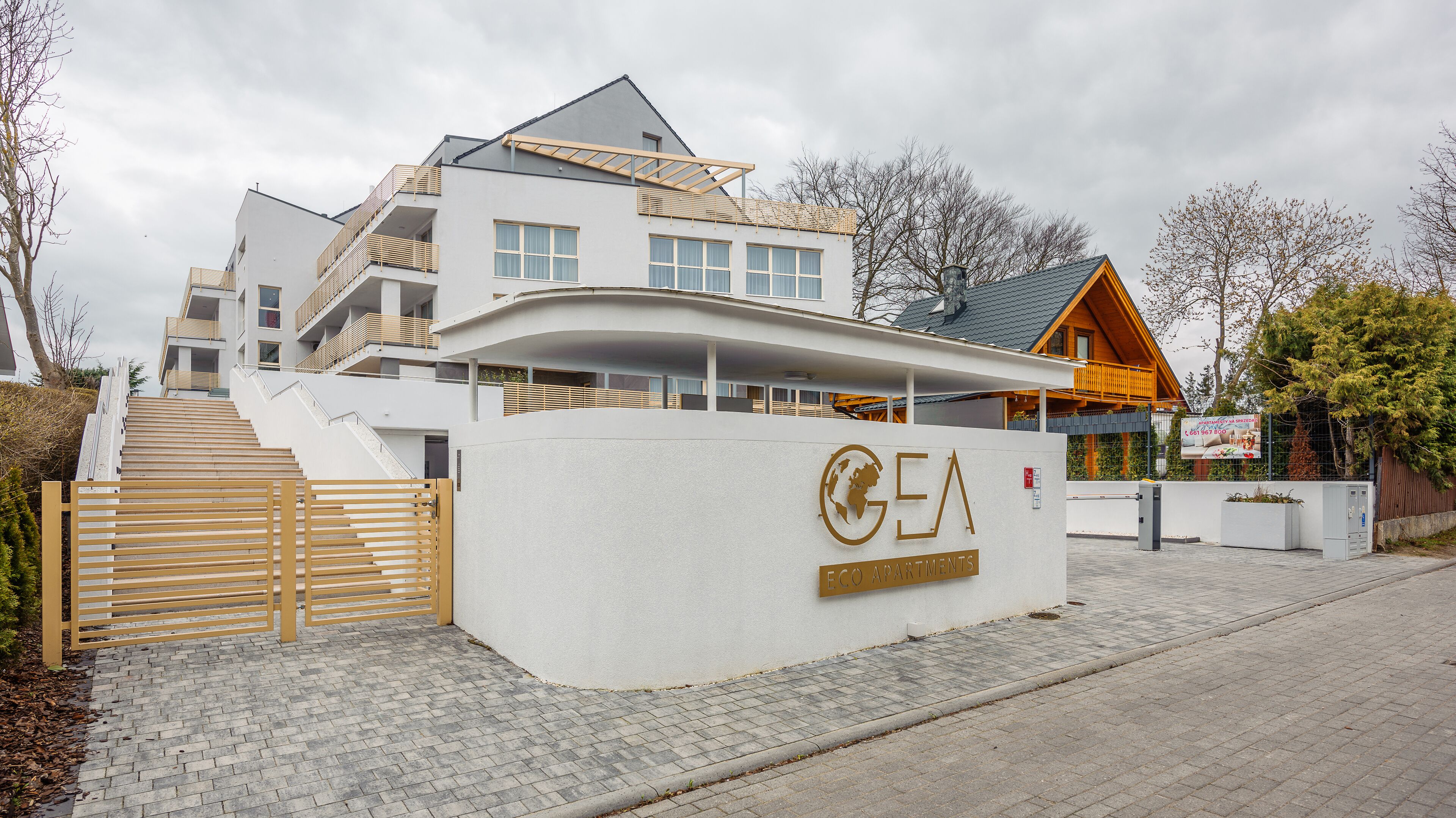 Ein modernes Gebäude mit einem gut sichtbaren Schild, auf dem "GEA Apartments" steht.