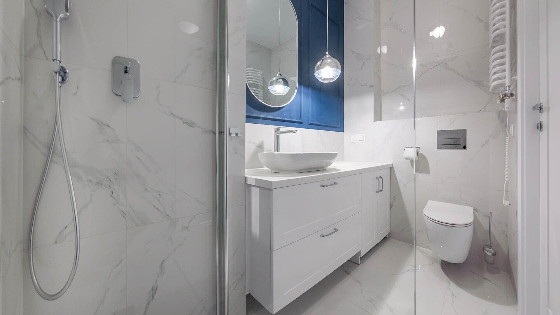 A modern bathroom with a glass-enclosed shower, a white sink with a vessel basin, and a toilet.