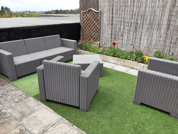 A patio area with wicker furniture and artificial grass. - Vacation, "Le Vernet la Varenne" vacation home for 5 people, Puy-de-Dôme, Auvergne (Le Vernet-Chaméane)