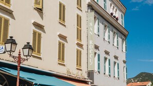 Un edificio con varias ventanas, un cartel que dice "SARI TAMARELLA" y una farola.
