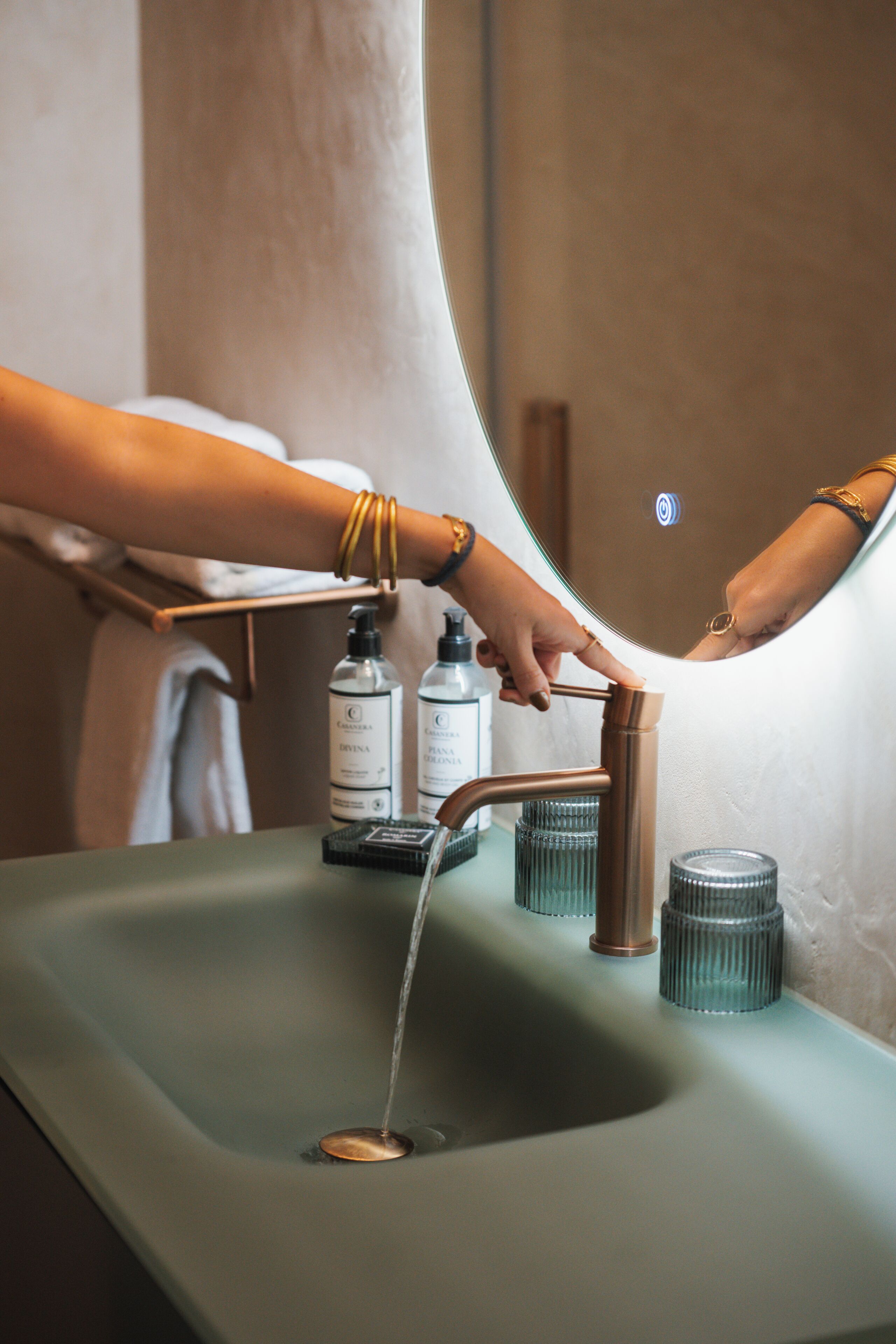 A bathroom sink with a faucet, soap dispenser, and a towel rack.