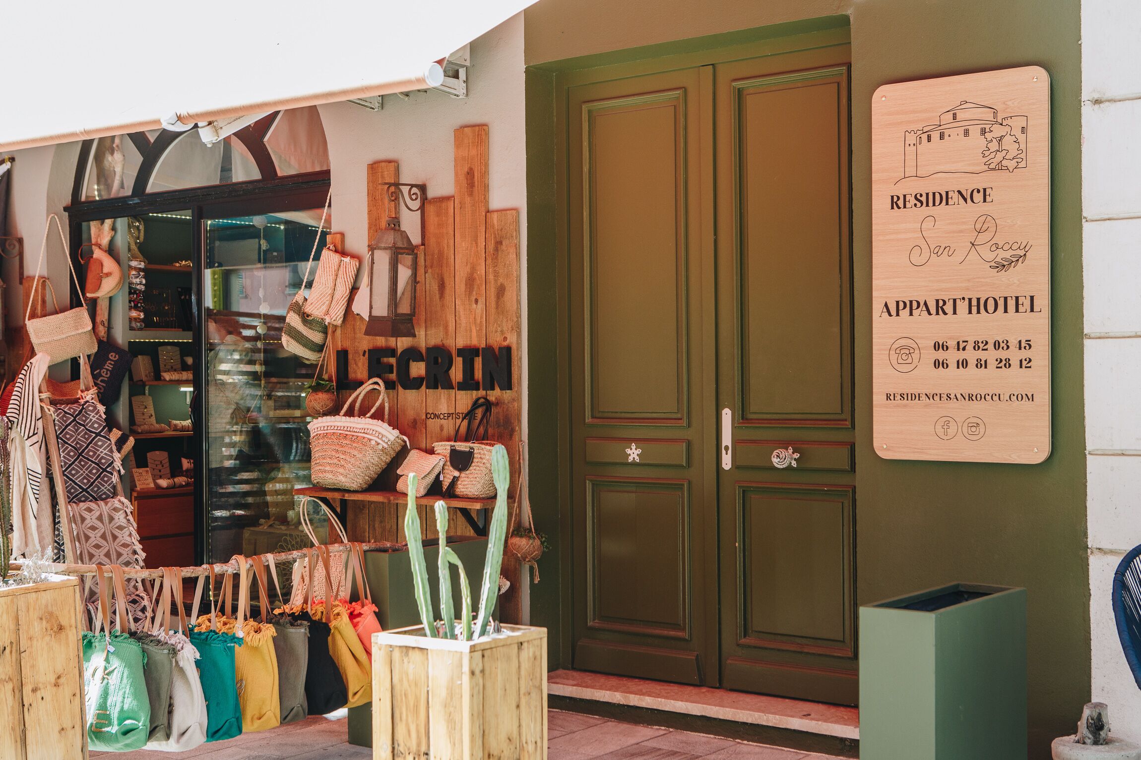 A wooden signboard with the text "RESIDENCE San Roccy APPART HOTEL" and contact details.
