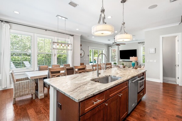 A spacious kitchen with a large island, wooden cabinets, and a dining area with a table and chairs. - Take-It-Easy — You've Earned This / Private Pool / 1 Min Bike to Beach & Gulf Place / 4 Bikes (Santa Rosa Beach)