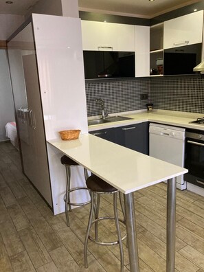 Full-size fridge, stovetop, cookware/dishes/utensils, paper towels
