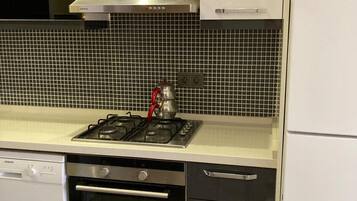 Frigorífico grande, placa de cocina y utensilios de cocina