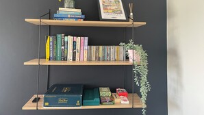 A bookshelf with books, a framed picture, and a small plant. - 2-bed Flat in Summerbridge Harrogate, Pet Friendly (Harrogate)