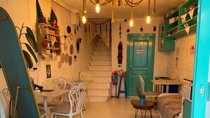 A cozy living room with a staircase, a dining area, and a kitchen area. - Aracati Pansiyon (Cesme)