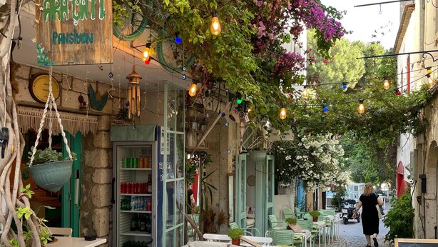 An outdoor café with white tables and chairs, a menu board, and a sign reading "Pansiyon". - Aracati Pansiyon (Cesme)