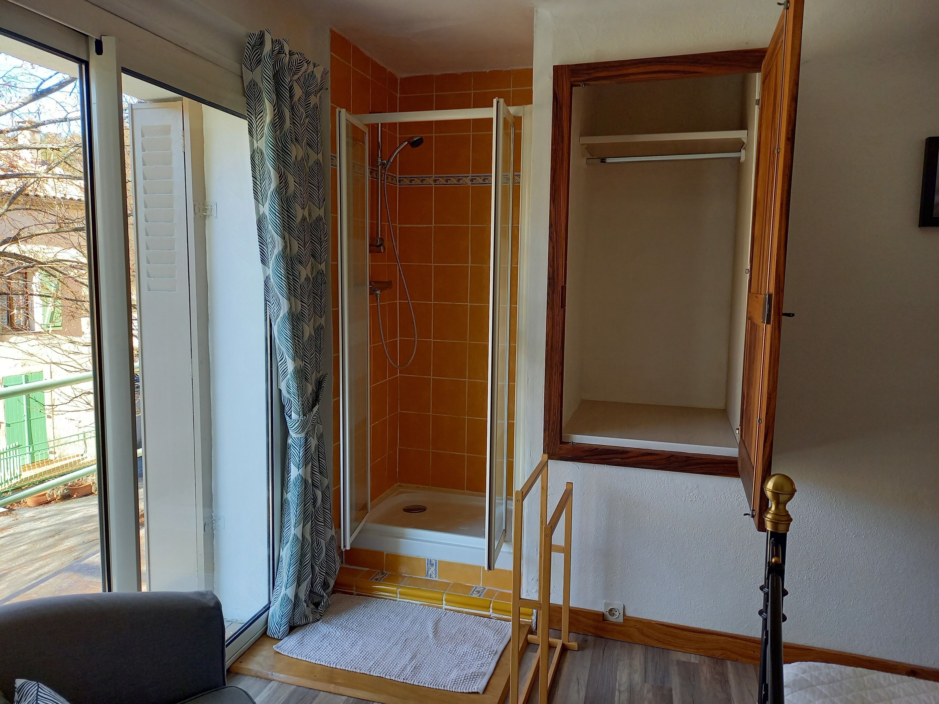 Ein Badezimmer mit Dusche, Fenster und Tür.