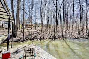 Relax on the lakeside deck with a retreat in the background, featuring a balcony and amenities for a peaceful stay.