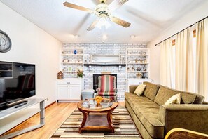 Relax in this stylish living room with a flat-screen TV, comfortable sofa, and fireplace.