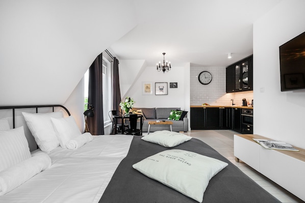 Comfort studio suite | Woonruimte | Een 55-inch flatscreentelevisie met kabelzenders en een televisie