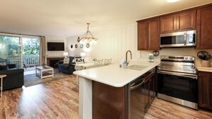 A modern kitchen with wooden cabinets, stainless steel appliances, and a large island.