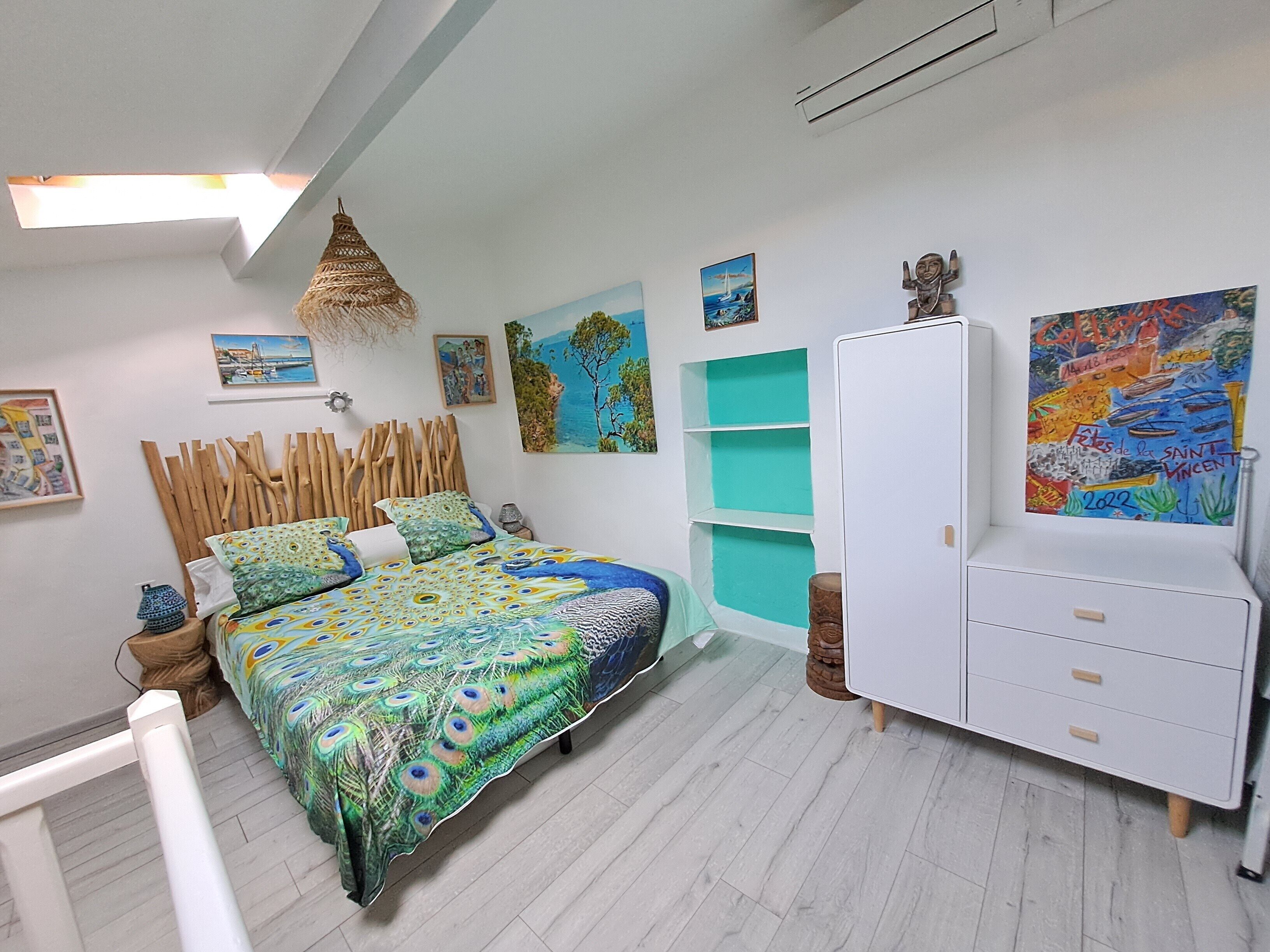 Ein Schlafzimmer mit einem Bett, einem Kleiderschrank und Bildern an den Wänden.