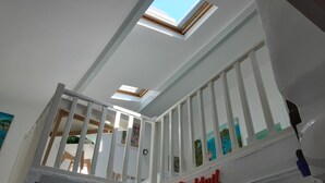 Une pièce dotée d’une lucarne, d’un balcon avec des balustrades blanches et d’une enseigne sur laquelle on peut lire « Cocktail ».