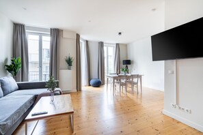 One-bedroom Suite with balcony | Área de sala de estar | Smart TV de 50 pulgadas con canales por cable y televisión