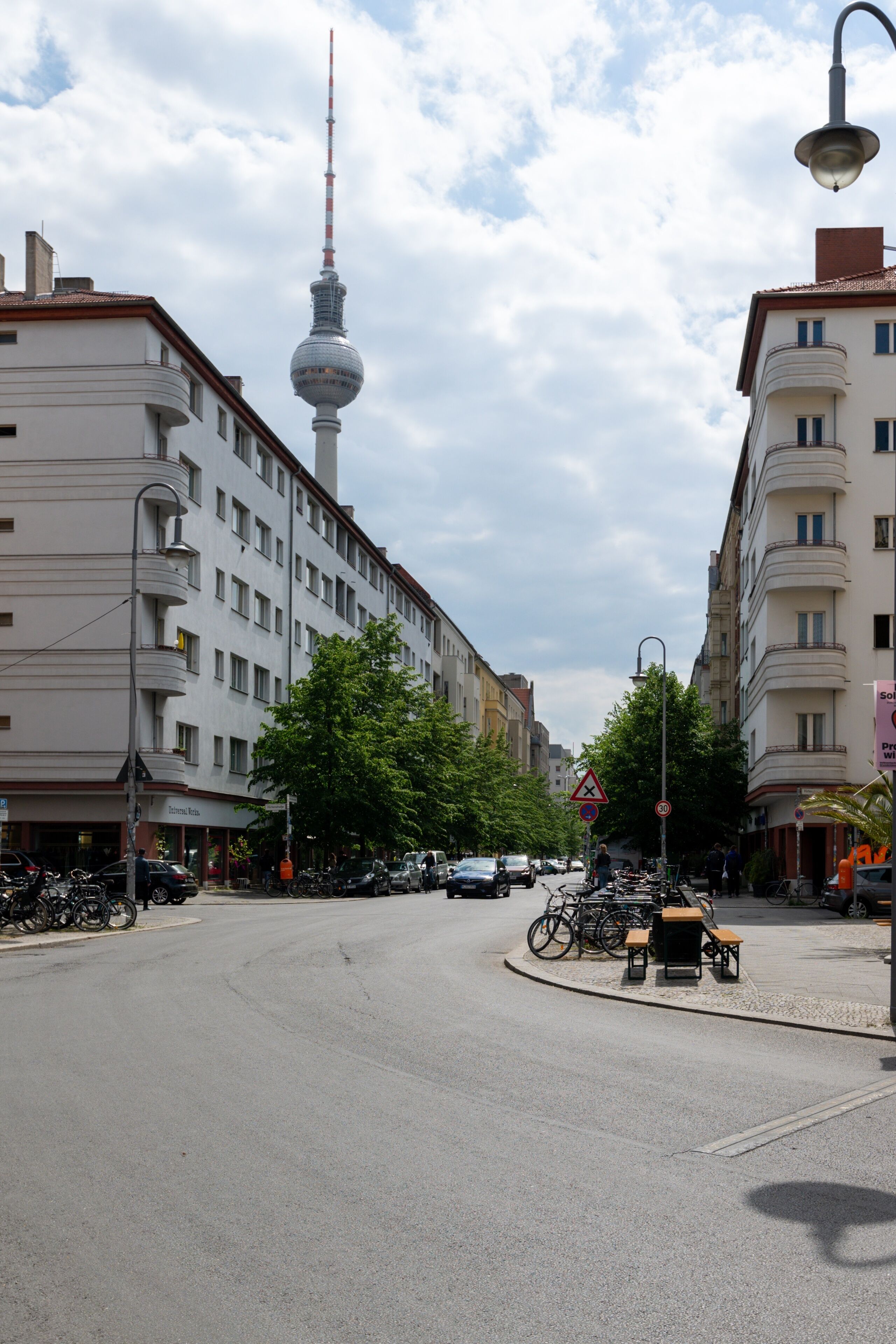 A street view with buildings, a roundabout, and a tower in the background.