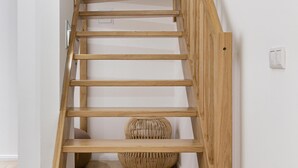 Eine Holztreppe mit einem gewebten Korb am Fuß.