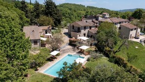 A villa with a swimming pool surrounded by lush greenery and stone buildings. - Antica Posta, Castellina in Chianti, Siena and Chianti (Castellina in Chianti)