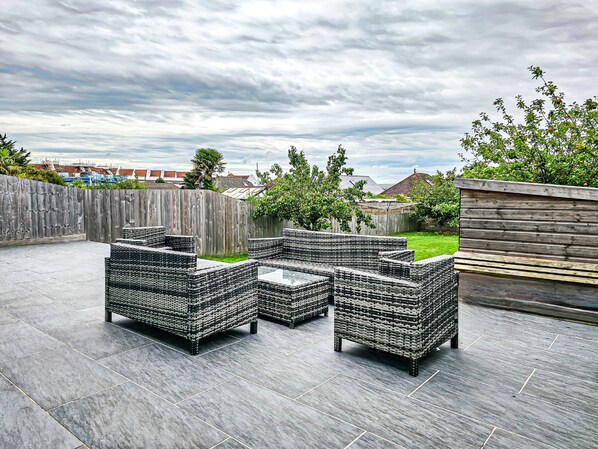 An outdoor patio with wicker furniture and a view of the neighborhood.