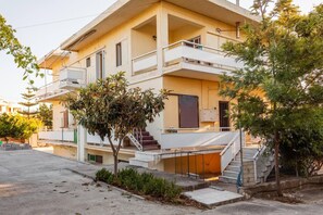 Een woonhuis met twee verdiepingen, een balkon, een trap en een kleine tuin.