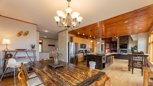 A spacious kitchen with a large wooden table, modern appliances, and a rustic ceiling. - Gorgeous Chalet - Incredible Views - Hot Tub - Fire Pit (Snowshoe)