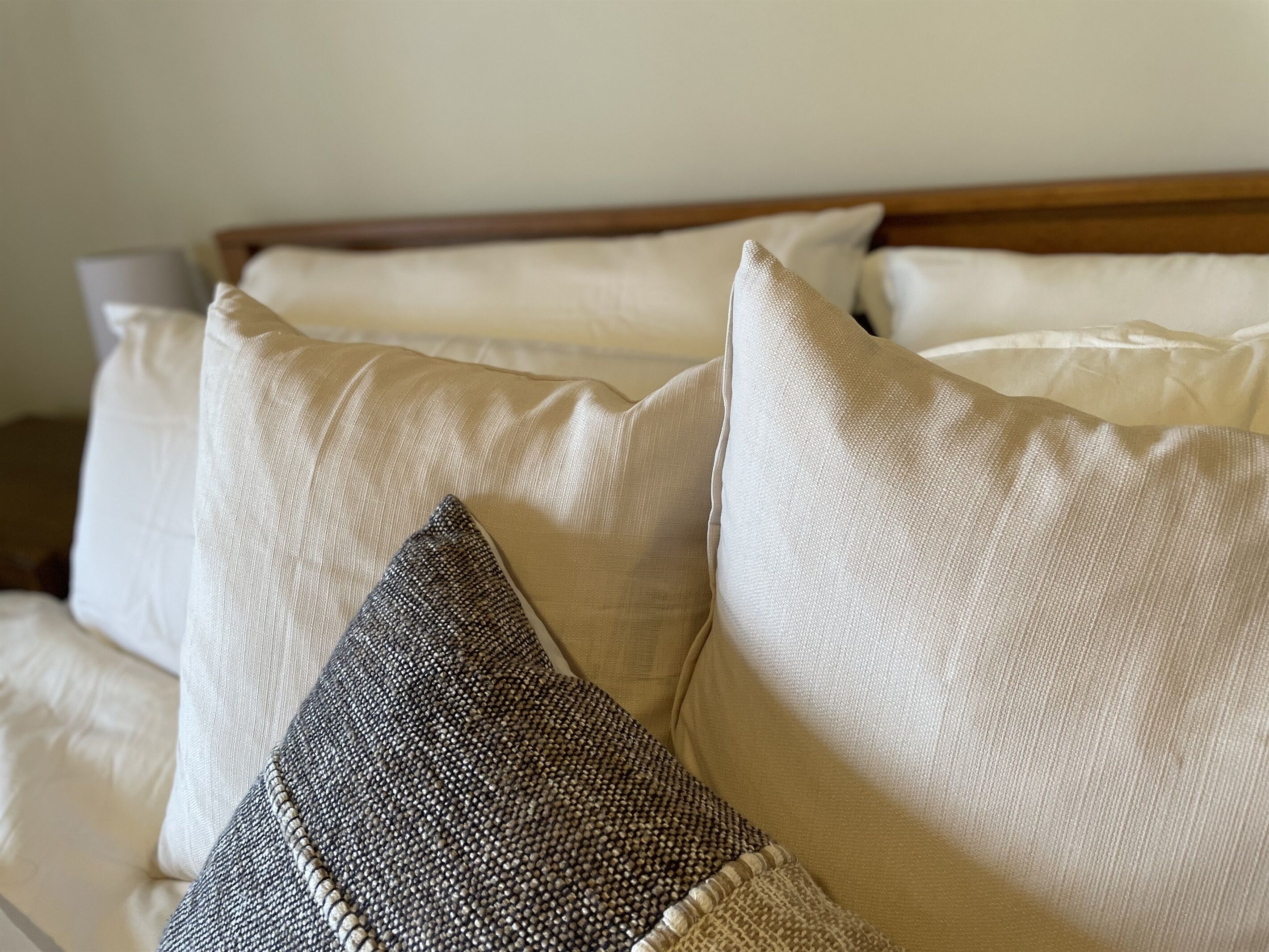 A bed with multiple pillows, including a textured one.