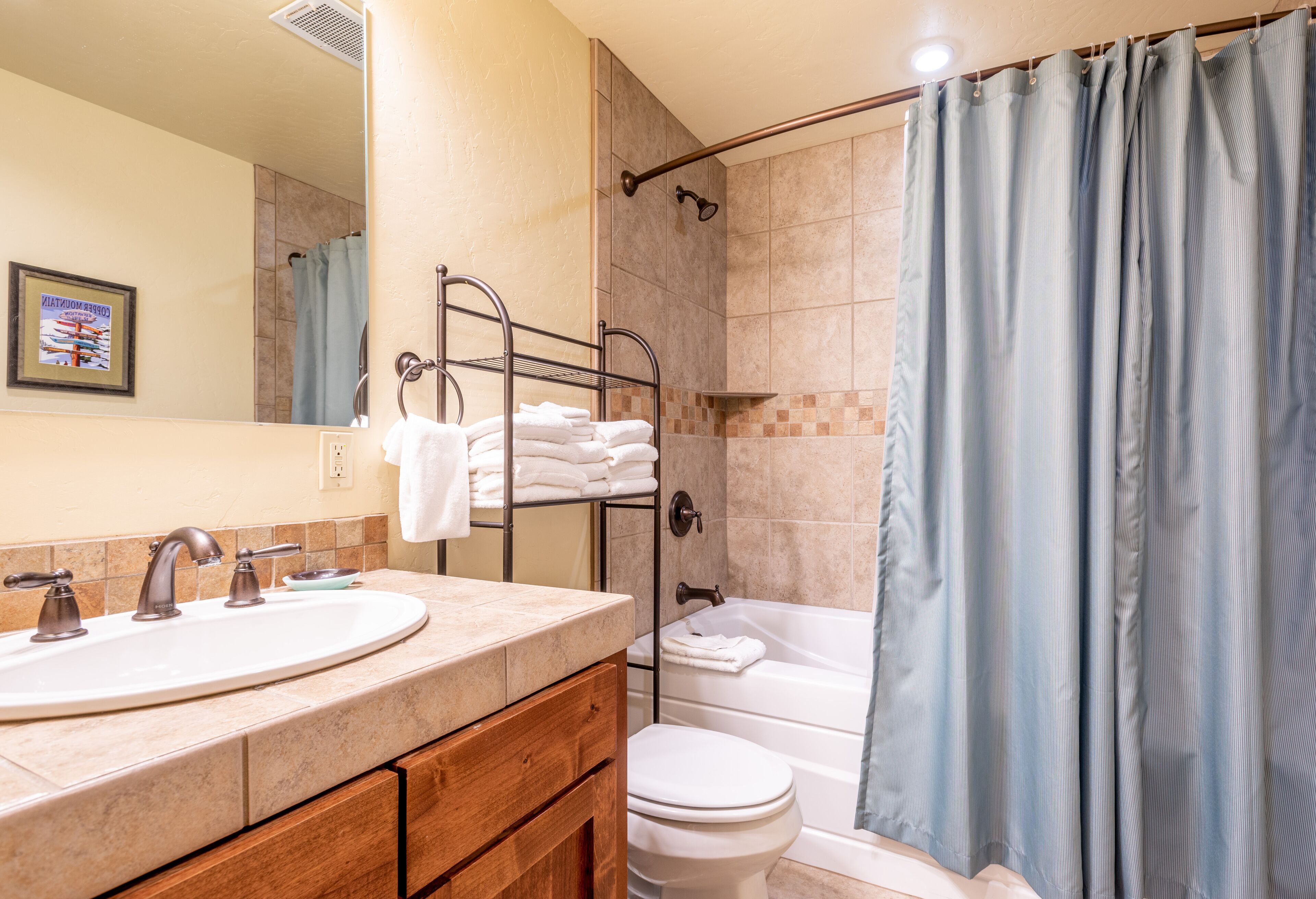 Une salle de bain équipée d’un lavabo, d’un miroir, d’un porte-serviettes, de toilettes et d’une baignoire.