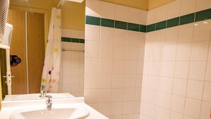 A bathroom with a sink, mirror, and bathtub.