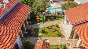 A courtyard with a swimming pool, outdoor seating, and a small garden area. - Villa Štrkalj (Policnik)