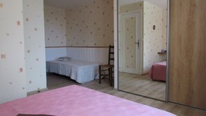 A bedroom with a bed, a chair, a wardrobe, and a mirror. - Apartment in stone house (Saint-Crépin-et-Carlucet)