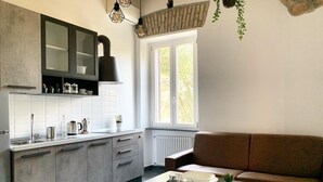 Une cuisine moderne avec un coin repas, comprenant un four encastré, une fenêtre avec vue et un canapé en cuir marron.