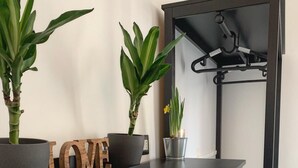 Une cuisine moderne avec un plan de travail foncé, un panneau en bois sur lequel est écrit le mot « AMOUR », et deux plantes en pot.