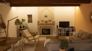 A cozy living room with a fireplace, a television, a bookshelf, and comfortable seating.