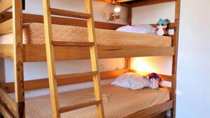A bunk bed with a wooden ladder, a small shelf, and a wall-mounted light fixture. - 50m from resort center, 2nd floor, swimming pool, balcony, tv, ski locker, 32m², Risoul (Risoul)
