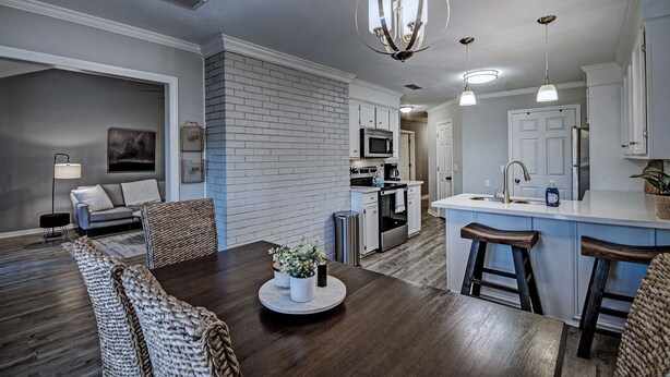 A modern kitchen with white cabinets, a central island, and pendant lighting. - Three Bedroom Home Reservoir Getaway (Brandon)