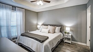 A bedroom with a bed, bedside tables, a ceiling fan, and a window with curtains. - Three Bedroom Home Reservoir Getaway (Brandon)