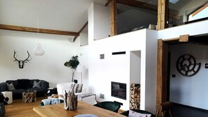 Een moderne woonkamer met een houten eettafel, een bank en een televisie.