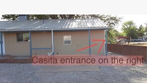 A building with a metal roof and a door marked "Casita entrance on the right."