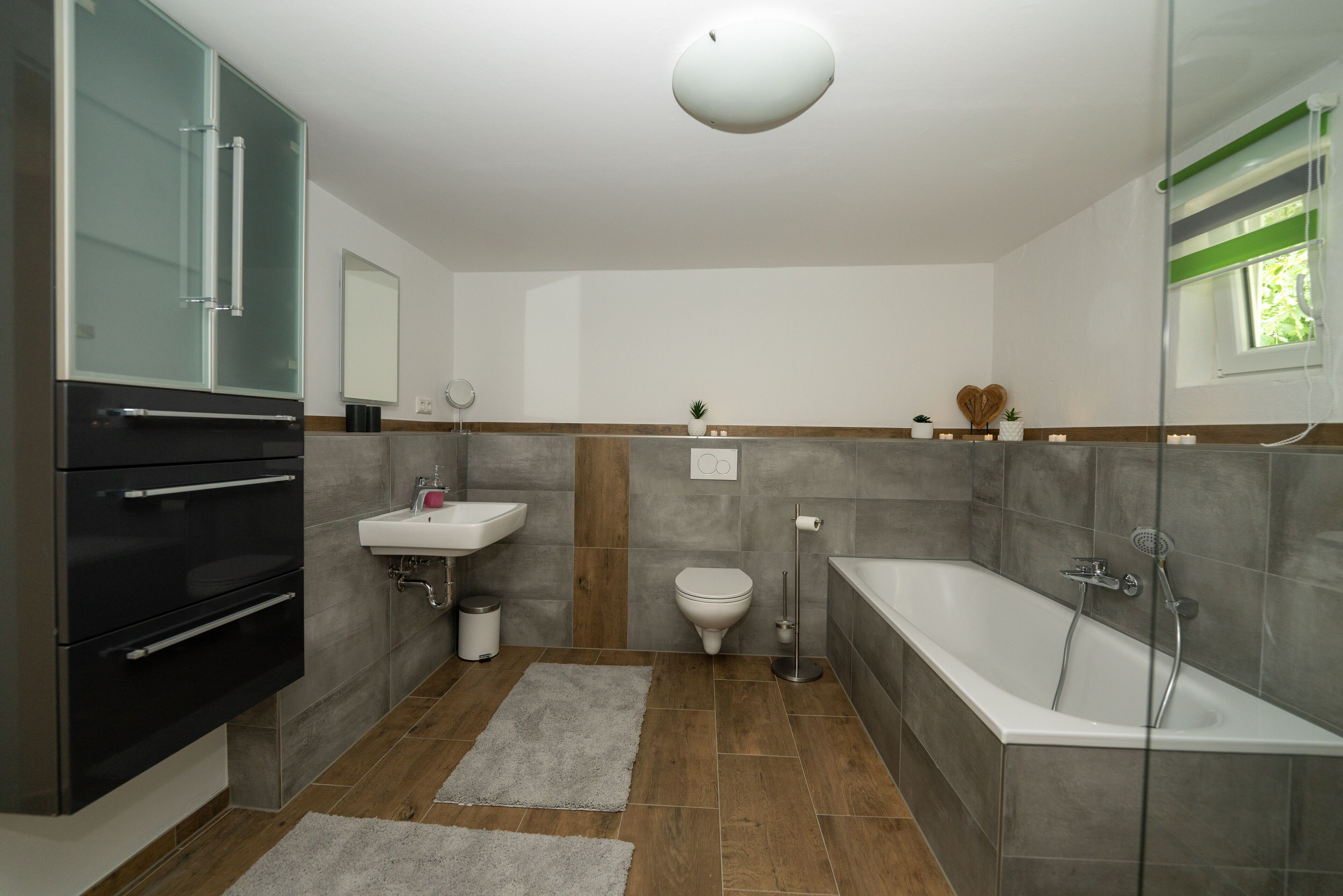 A modern bathroom with a built-in oven, sink, toilet, and bathtub.