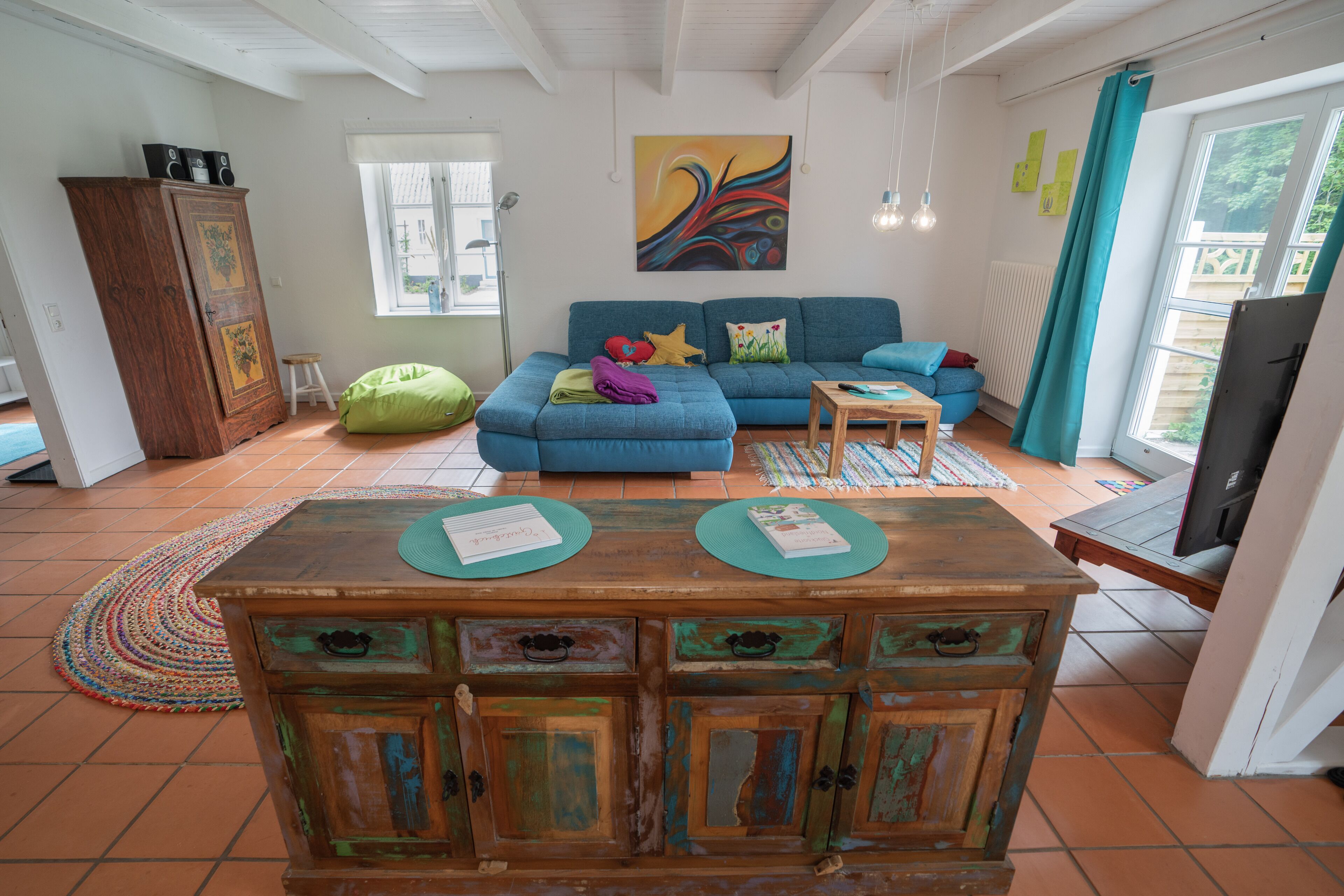 A living room with a blue sofa, a wooden coffee table, and a cabinet.
