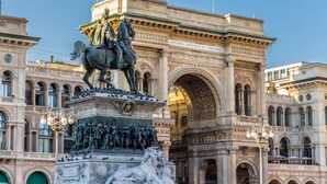 A grand historical monument with intricate carvings and a statue of a figure on horseback, set against a backdrop of classical architecture.