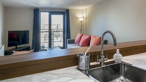 Une cuisine moderne équipée d’un évier, d’un plan de travail et d’un coin repas avec une table et des chaises.